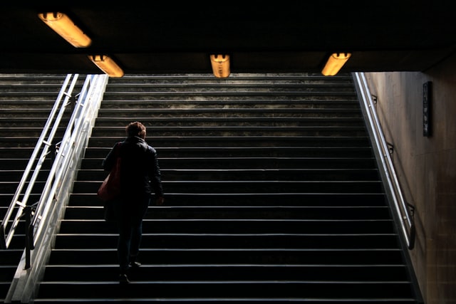 A walks upstairs with a backpack on his back.