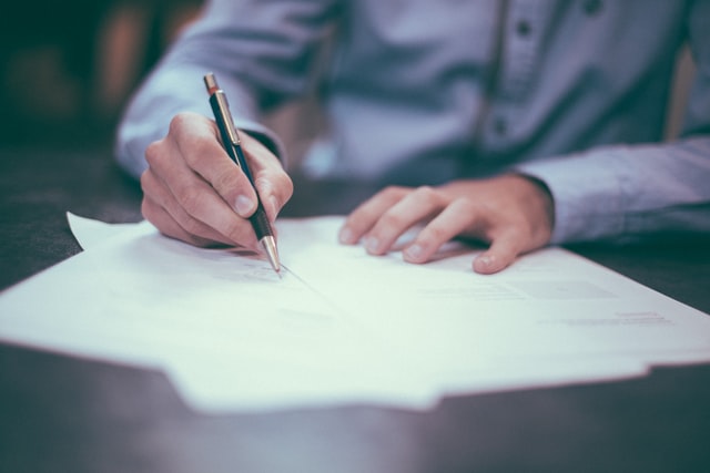 A man fills out a survey using a pen.