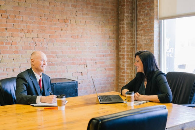 A man and a woman smile during a discussion at work.