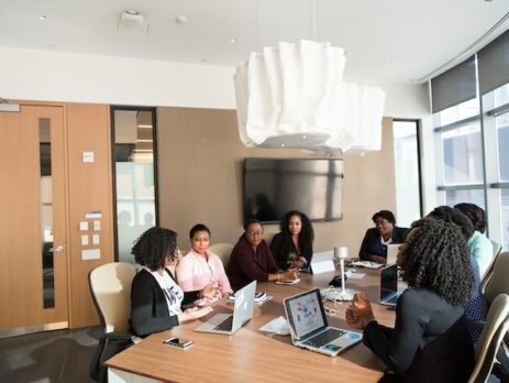 A workplace team sits around a table and negotiates. 