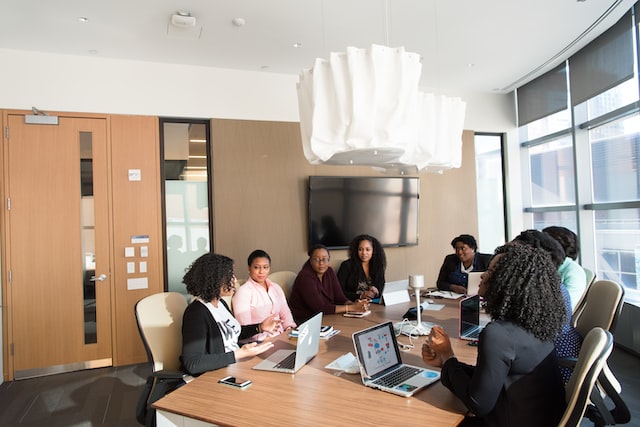 A workplace team sits around a table and negotiates. 