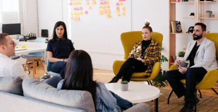 A business team sits in a circle discussing strategy. 