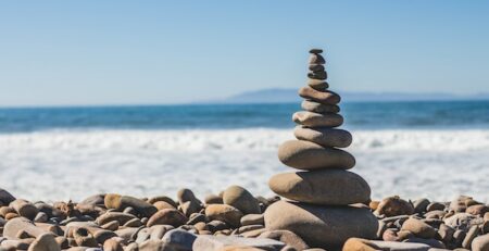 A pile of rocks balances by the sea.