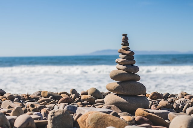 A pile of rocks balances by the sea.