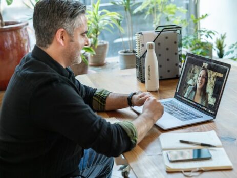 A man is being interviewed by a woman via a video interview. 