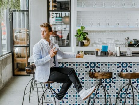 A man sits at the countertop in a modern bar. 