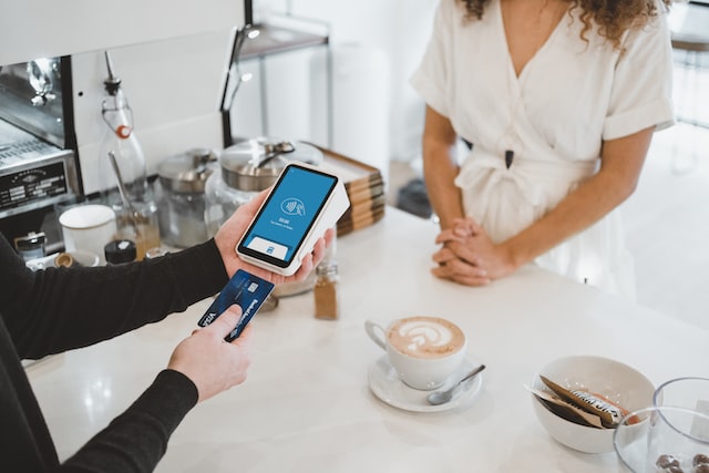 An individual uses a loyalty card at checkout.