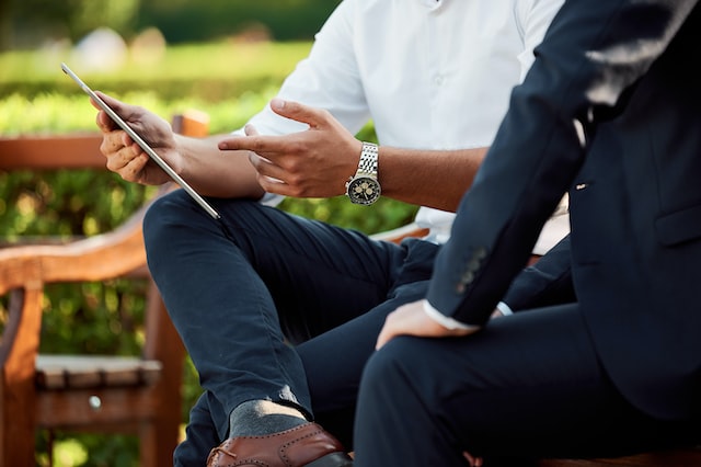 Two men discuss information which is presented on an ipad.