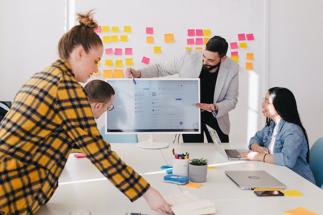 Alt-Text: A group of people works on a project in a conference room.