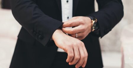 A man pulls down his suit sleeves. 