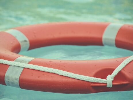 An orange life preserver floats in a pool. 