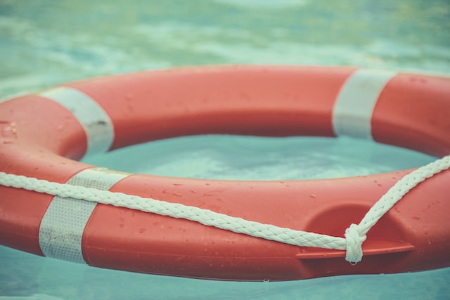 An orange life preserver floats in a pool. 