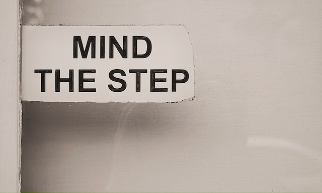 A white sign says mind the step. 