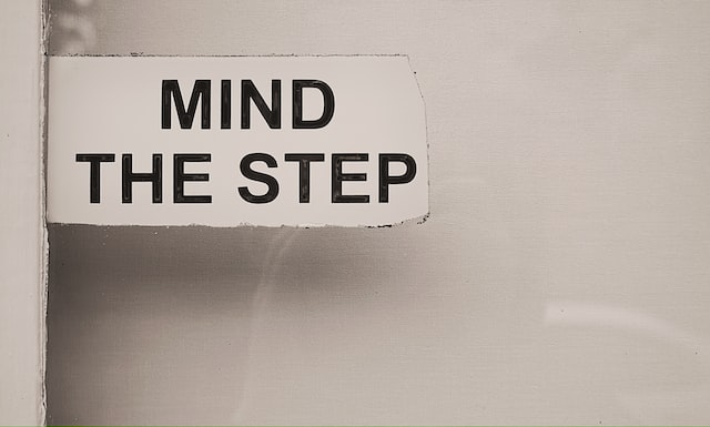 A white sign says mind the step.