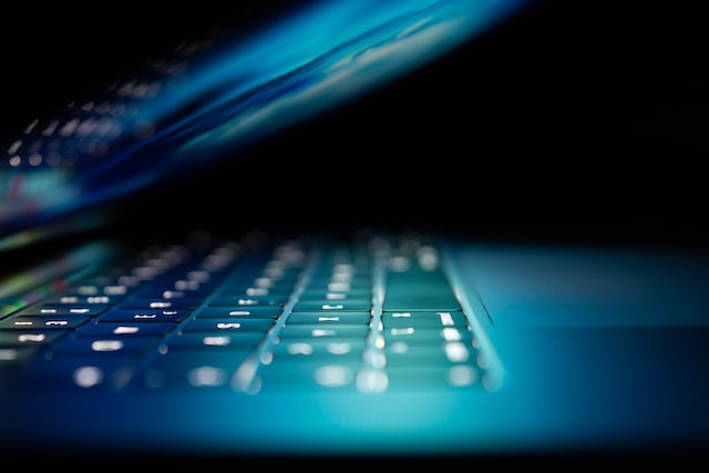 A laptop computer is illuminated while half open.