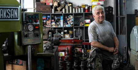 A man stands in a family-owned mechanic shop. 