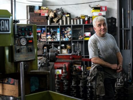 A man stands in a family-owned mechanic shop. 