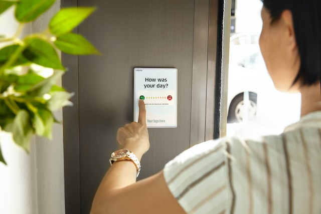 A woman rates her experience via a panel with buttons. 