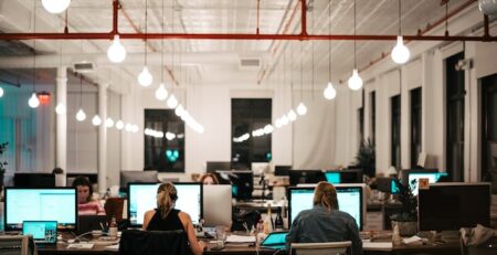 Some employees work on computers in an office setting. 