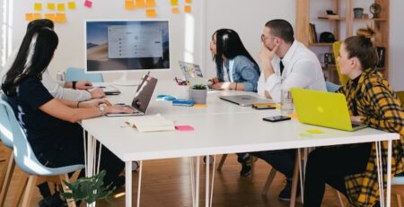 Multiple professionals engage in a meeting. 