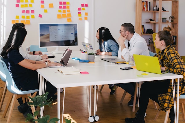 Multiple professionals engage in a meeting. 