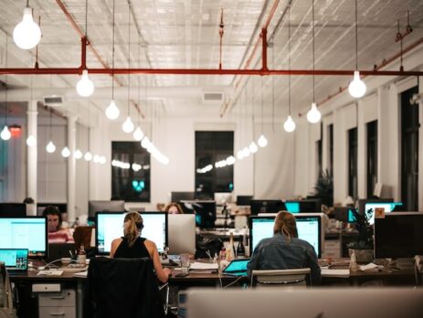 Some employees work on computers in an office setting.