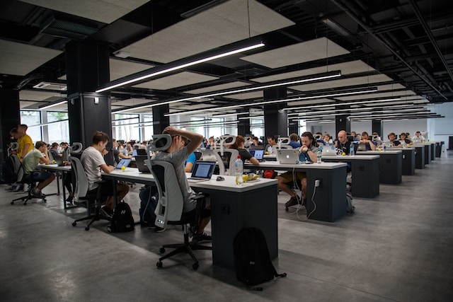 A busy office with many occupied desks.