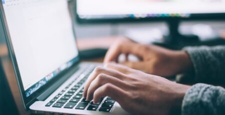 An individual researches data on a laptop computer. 