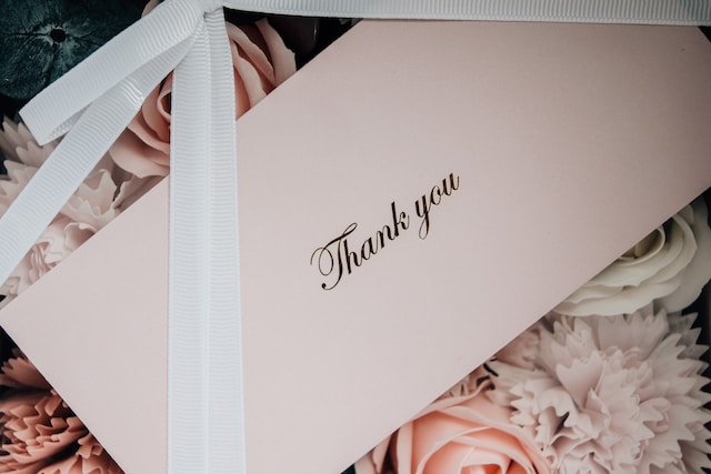 A thank you note on top of flowers.