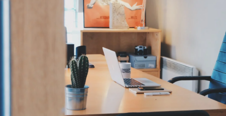 An empty office with a laptop on a desk.