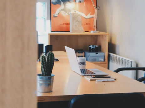 An empty office with a laptop on a desk.