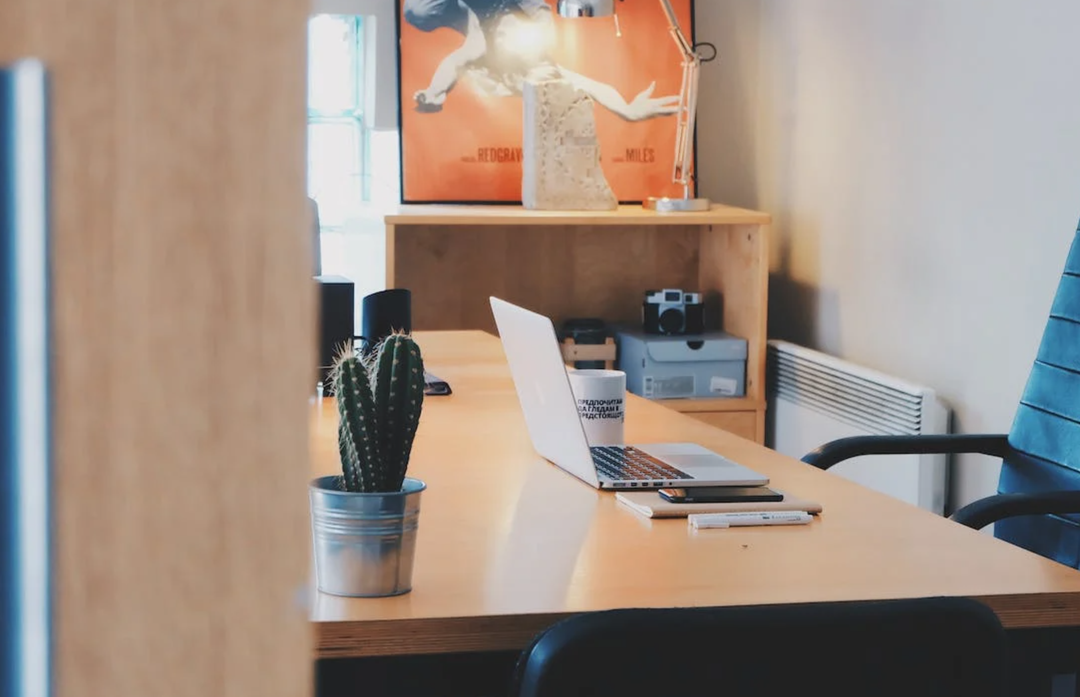 An empty office with a laptop on a desk.