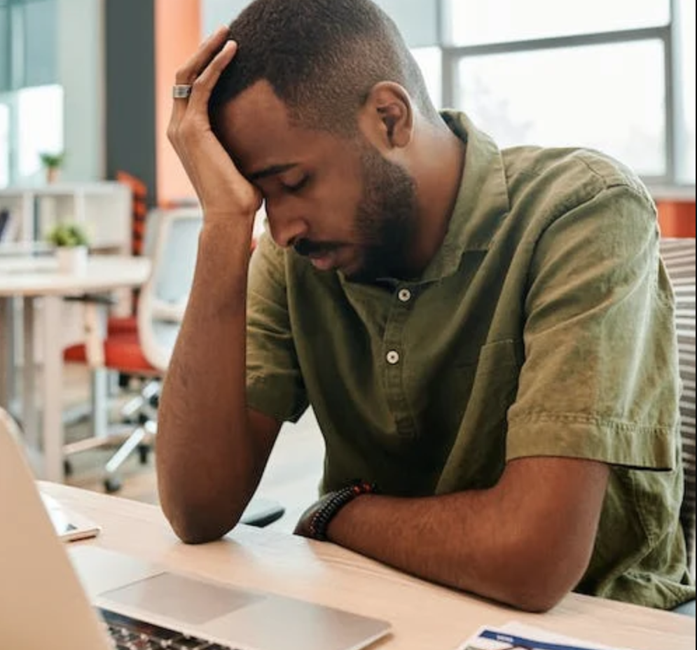 A tired man sitting at his desk in an office.