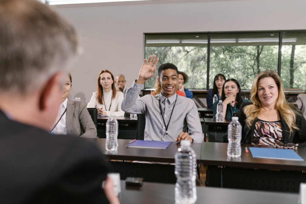 A man raising his hand in a business meeting.