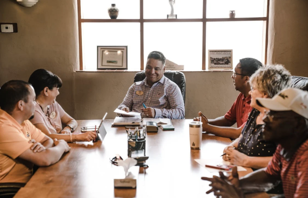 People sitting around a table in a meeting.