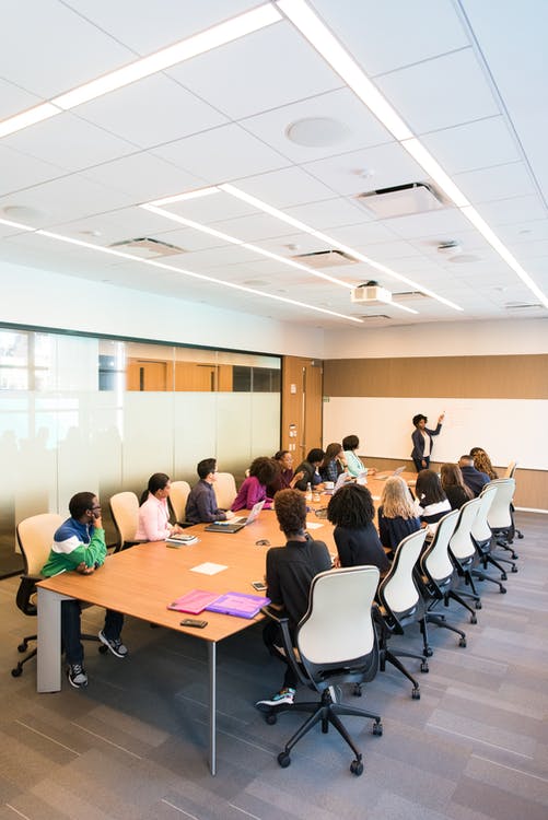 People sitting around a table having a meeting in a conference room.