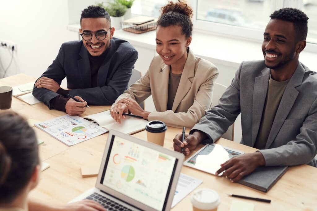 Three people smiling while having a meeting