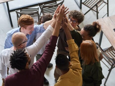 A group of employees holding each other’s hands.