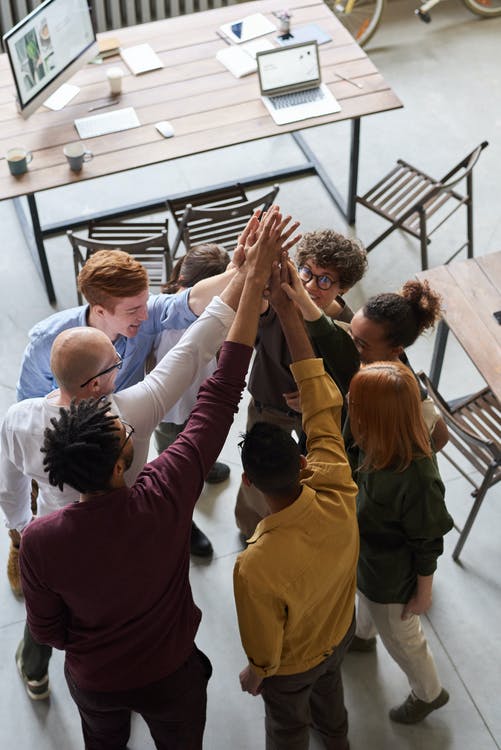 A group of employees holding each other’s hands.