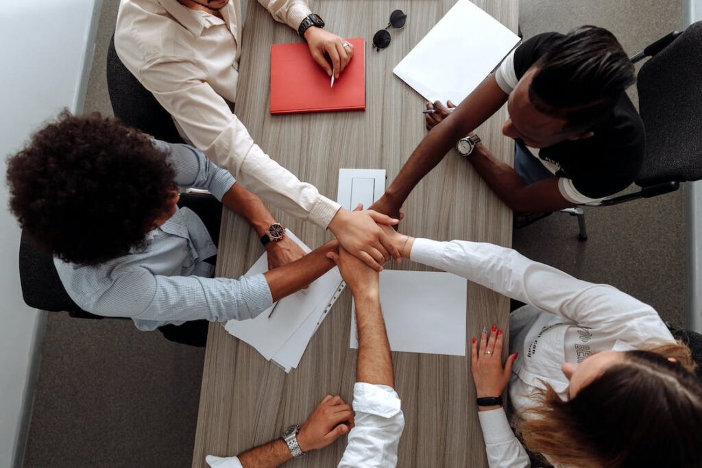 Employees holding their hands together.