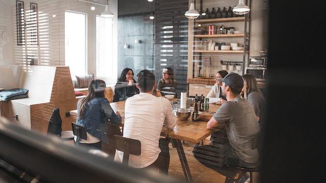 A group of employees sits around a table in a breakroom.