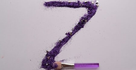 A large letter Z is made out of purple glitter using a brush. 