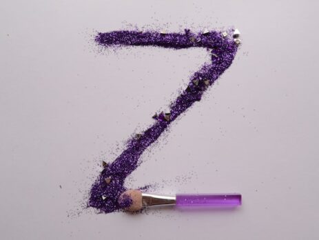 A large letter Z is made out of purple glitter using a brush. 