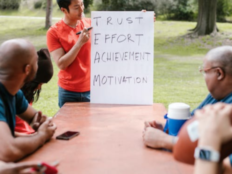 Man speaking to a group of people about team building.