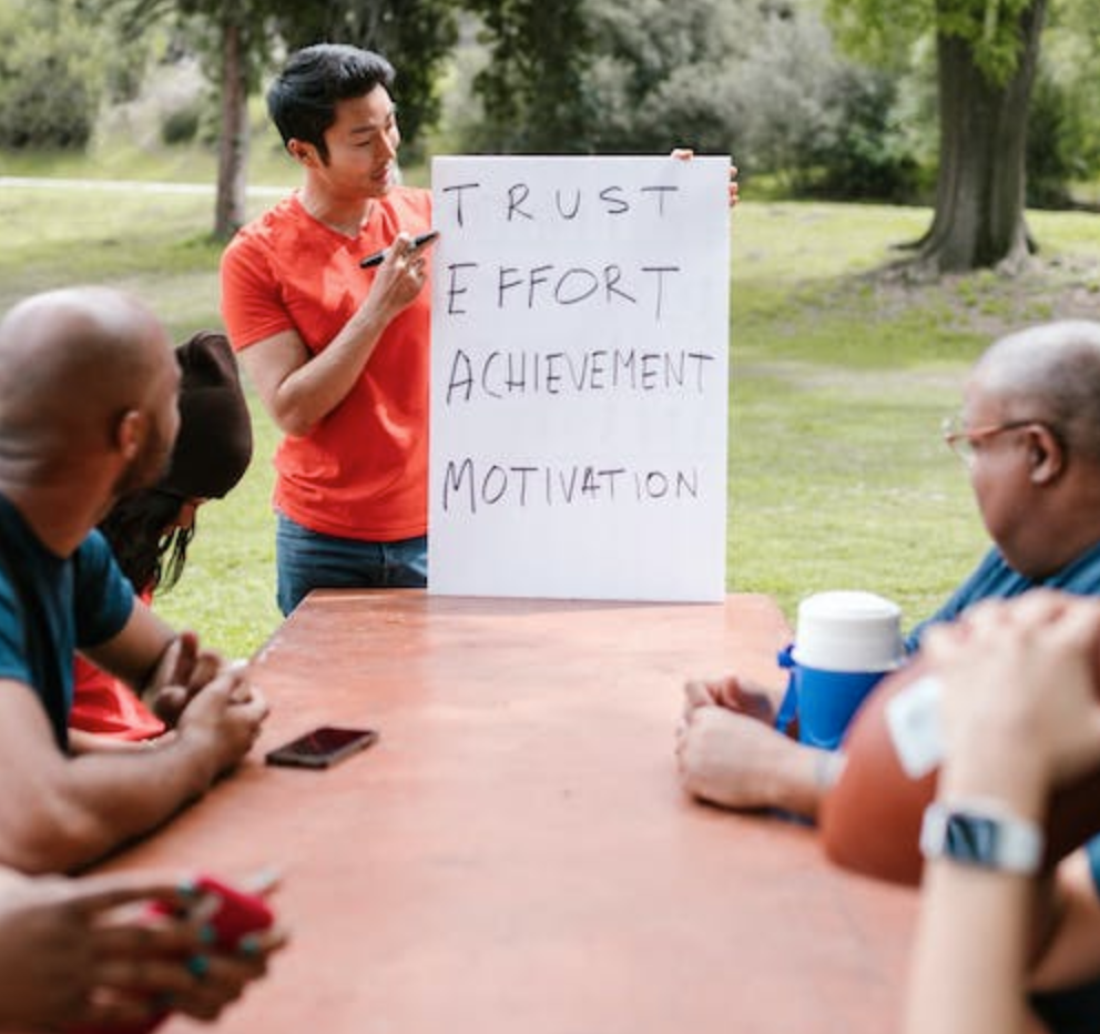 Man speaking to a group of people about team building.