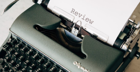 A paper with the word “Review” written on it on a typewriter.