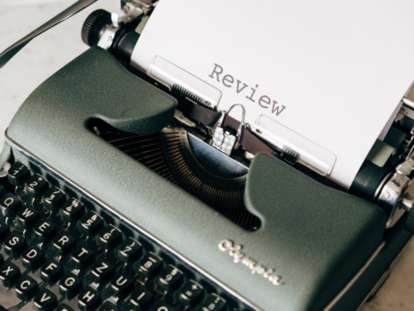 A paper with the word “Review” written on it on a typewriter.