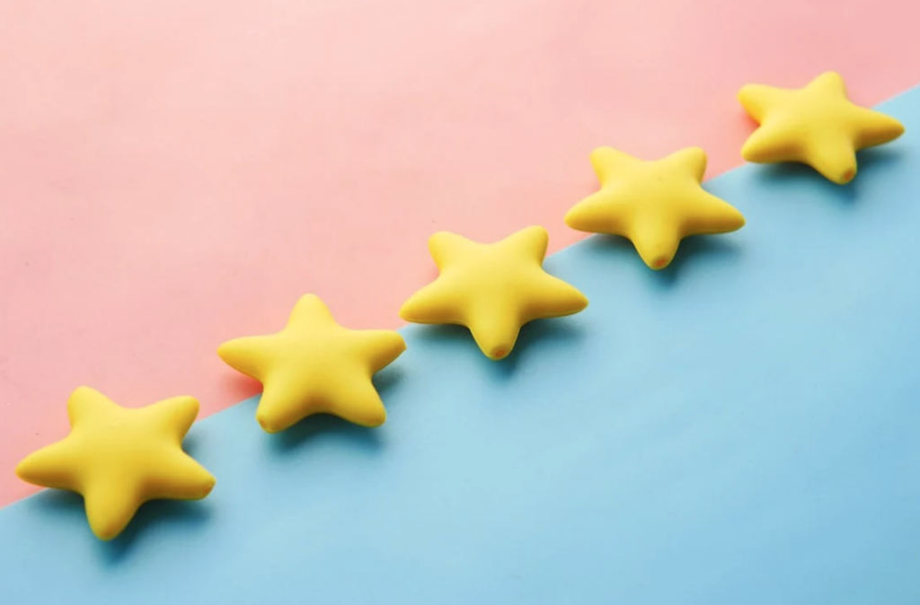 Five yellow stars in a straight line on a blue and pink background.