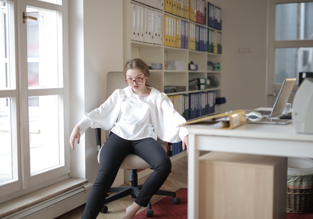 Woman sitting nonchalantly in office