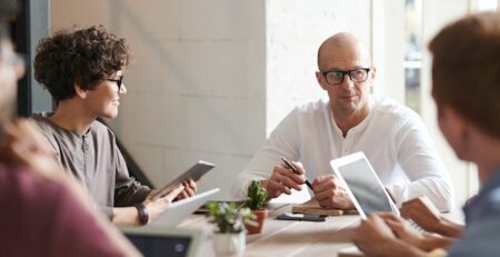 Man sitting in front of young employees  